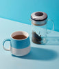 Brew Tea Co. Moroccan Mint serving suggestion: a cup of tea beside a glass teapot.