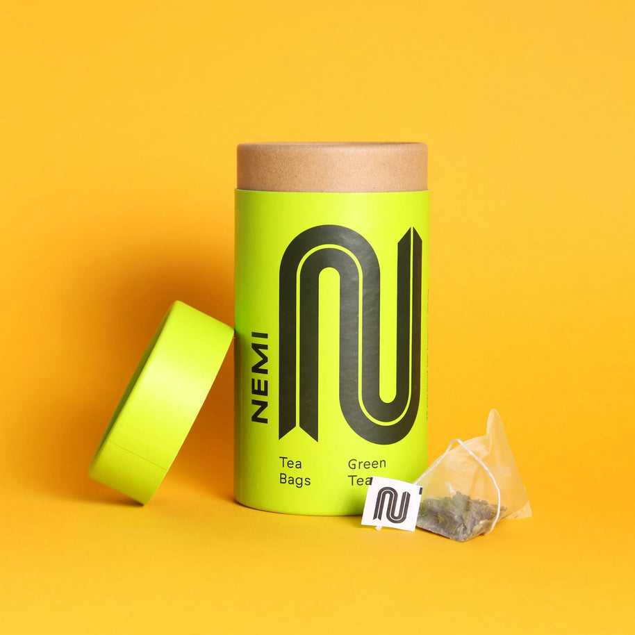 NEMI Organic Green Tea — lime green branded retail tube of 15 pyramid teabags with the logo clearly visible